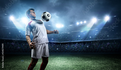 Football player withstand a ball with his chest in the stadium