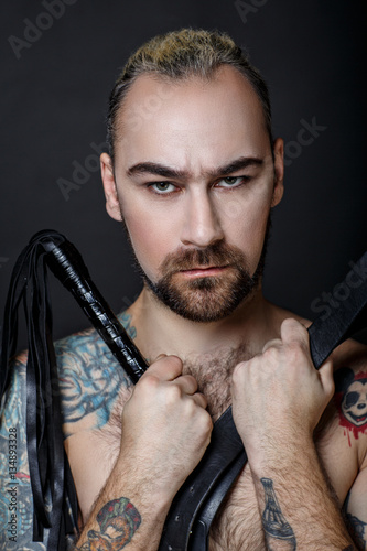  man with a whip and tattoo