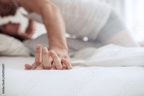 Couple enjoying sensual foreplay on bed