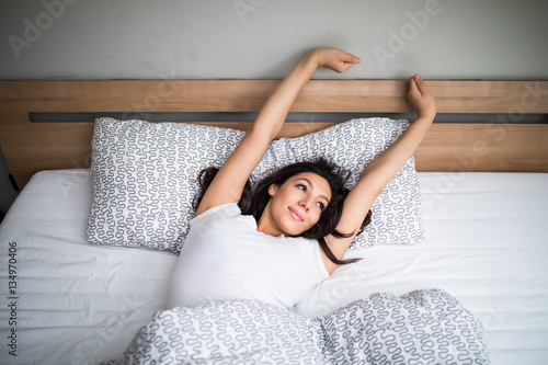 Woman stretching in bed after wake up