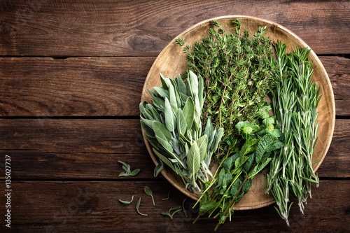 various fresh herbs, rosemary, thyme, mint and sage on wooden background