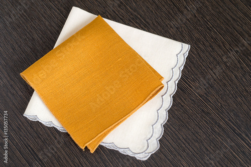  Two handkerchiefs . Two handkerchiefs of cotton fabric with treated the edges on a dark wooden background.
