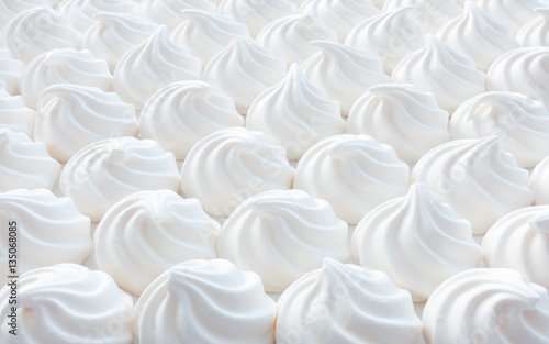 Closeup of white mini meringue swirls as food background. 