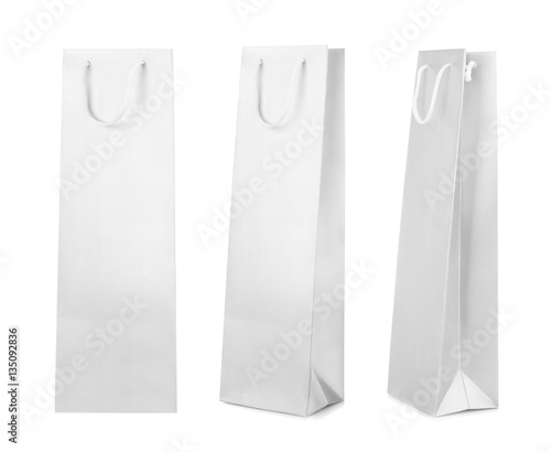 Different views of paper bag for wine bottle on white background