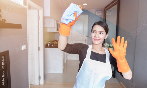 Asian young maid cleaning the mirror at home, Cleaning service concept