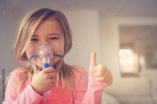 Little girl using inhaler.
