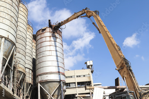 Demolition crane dismantling old tanks