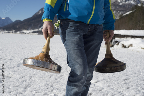 Mann mit Eisstöcken auf Grundlsee mit Schneeschicht, Bavarian curling in Austria