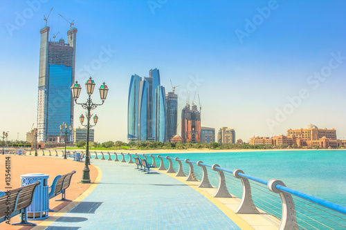 Dhabi skyline from cycle paths of Corniche. Abu Dhabi, United Arab Emirates, Middle East. Modern skyscrapers and landmark on background. Summer holidays concept.