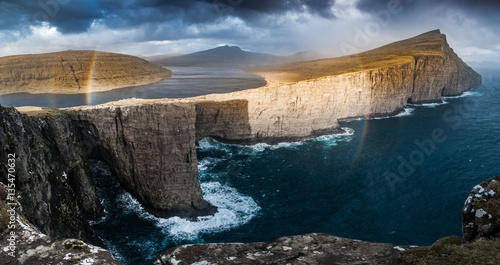 Panoramatic view into the cliffs and lake with circle rainbow, Traelanipa, Faroes Islands