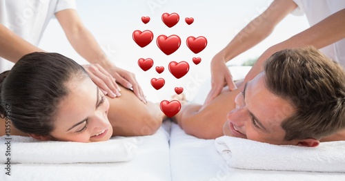 Masseur giving massage to couple at spa