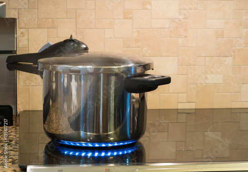 Stainless steel pressure cooker on hob
