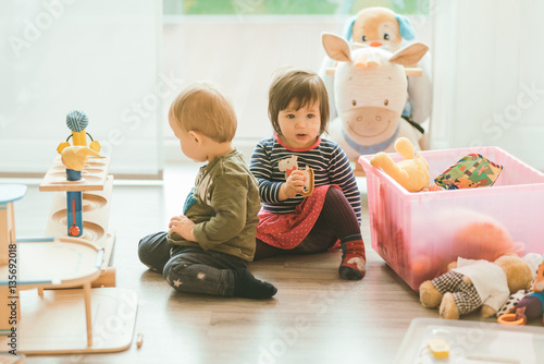 little girl and boy playing with toys by the home
