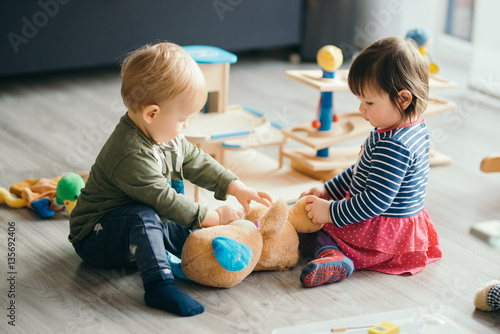 little girl and boy playing with toys by the home