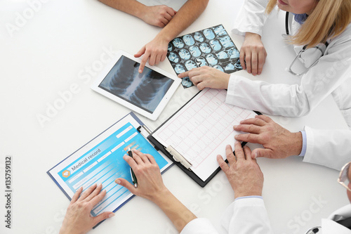 Team of doctors exploring lungs roentgenogram in clinic