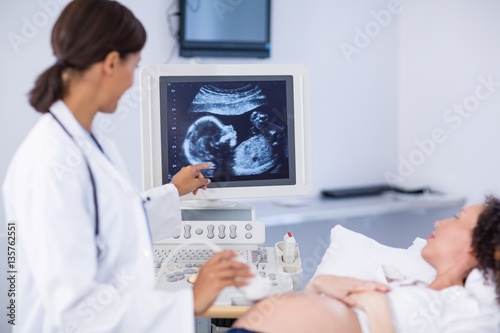 Doctor doing ultrasound for pregnant woman