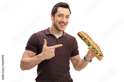 Young man holding a sandwich and pointing