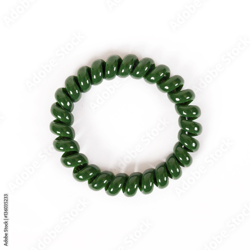 Round green spiral elastic band for hair is isolated on a white background