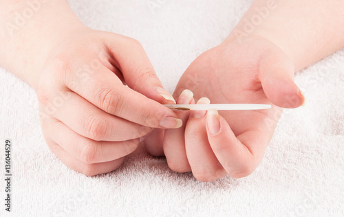 Woman using nailfile during making menicure herself