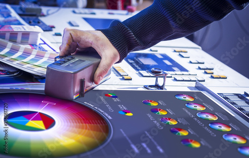 Young man in the process of offset printing and color correction