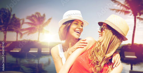 smiling young women in hats on beach