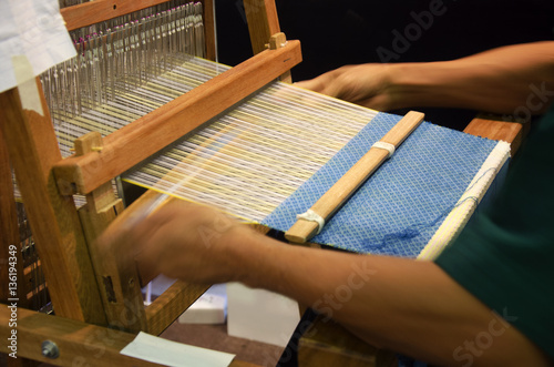 Thai people using small loom or weaving machine for weaving show