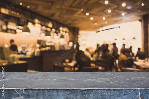 Stone table top and blurred bokeh cafe and coffee shop interior