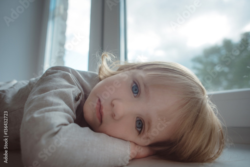 Little Girl with blue eyes on the window
