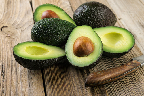 Fresh sliced avocado on wooden table. Vegetarian food concept.