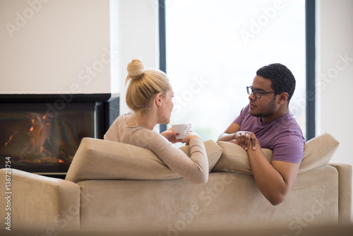 Young multiethnic couple in front of fireplace