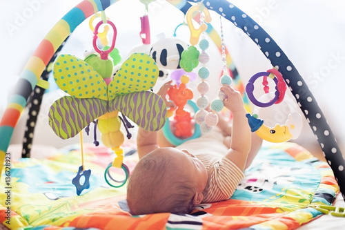 baby lying on Developing rug.