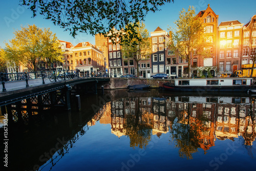 Beautiful sunset in Amsterdam. Highlighting sun buildings and bo