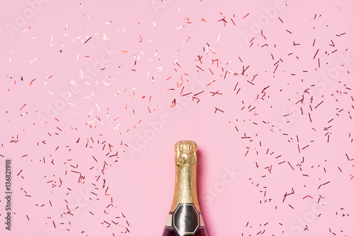 Flat lay of Celebration. Champagne bottle with colorful party st