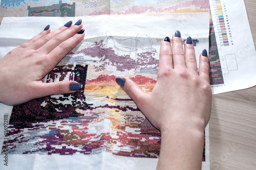 Female hand embroidered cross-stitch pattern under the scheme