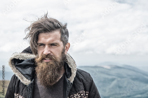 bearded handsome serious man on mountain top