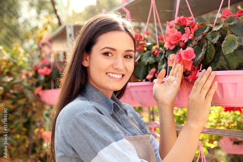 Pretty young woman with begonia flowers, close up view