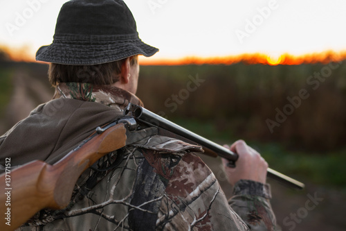 Hunter with rifle over his shoulder