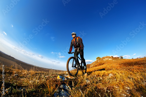 Mountain Bike cyclist riding single track outdoor with blue sky on background