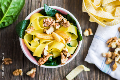 Top View Pasta with Walnuts and Fresh Spinach Leaves