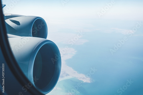Airliner jet engines and coastal landscape