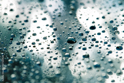 the Abstract grey background of water drops on glass with reflection, bockeh, macro