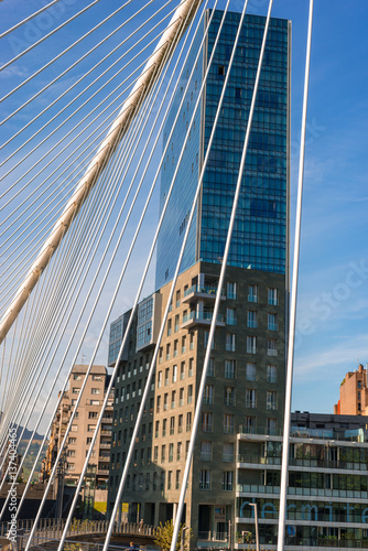 The bridge Puente Zubizuri and the Isozaki Atea, Basque for Isozaki Gate, twin towers in Bilbao, Spain. The high-rise buildings are the tallest residential buildings in the city