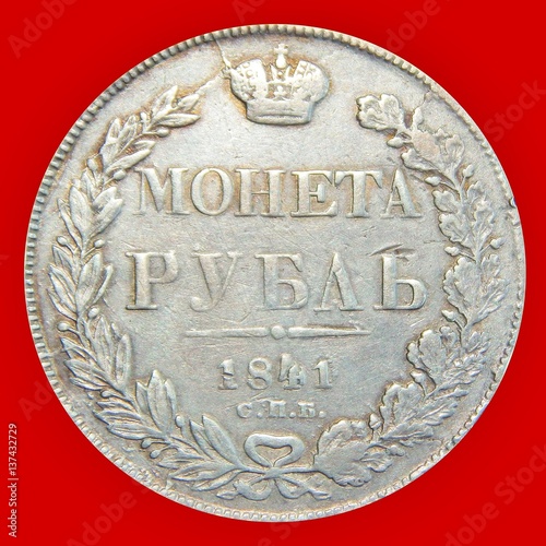 old silver Russian coin one ruble in 1841 on an isolated red background