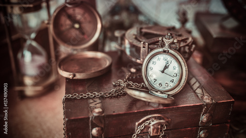 Antique compass old collection on a wooden treasure box in vintage style image.