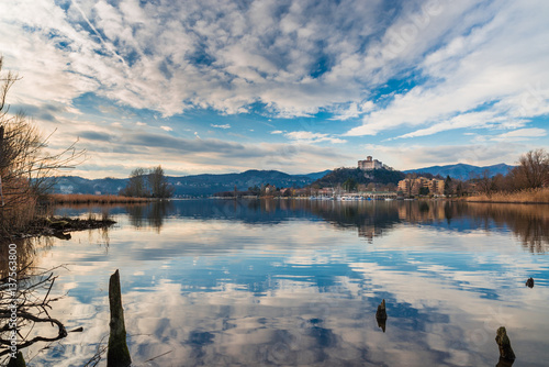 Lake Maggiore, panorama of the small village of Angera, the medieval fortress Borromea and nature reserve Bruschera, Italy