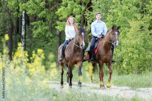 Young couple enjoying horseback riding.