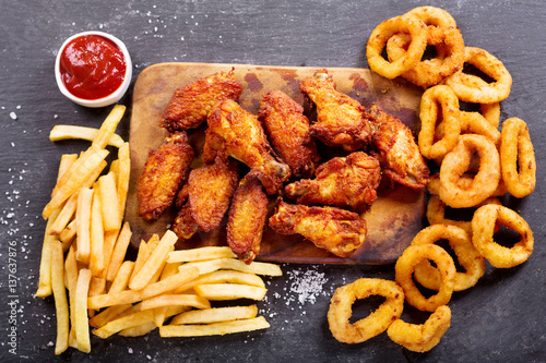 fast food meals : onion rings, french fries and fried chicken