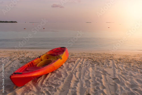 Kayak at the tropical beach at beautiful sunset. Silhouette beautiful tropical Maldives resort hotel and island with beach and sea on sunset sky for holiday vacation background concept.