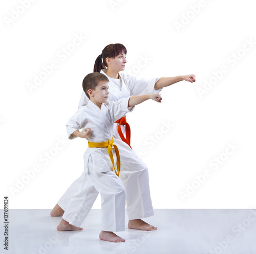 With yellow and orange belt the mother and son are hitting a punch arm