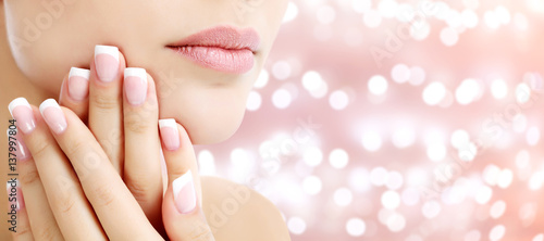 Beautiful young woman with healthy skin and french manicure